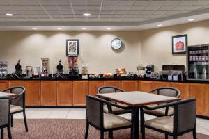 un ristorante con bancone, tavoli e sedie di Wingate by Wyndham Louisville East a Louisville