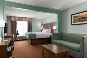 una camera d'albergo con letto e divano di Wingate by Wyndham Louisville East a Louisville