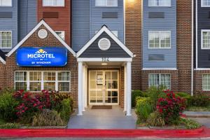 Microtel Inn by Wyndham Raleigh-Durham Airport في موريسفيل: فندق فيه لافته على واجهة مبنى