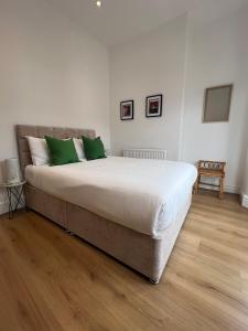 una camera da letto con un grande letto con cuscini verdi di Liverpool Cherry House - 4 Bedrooms a Liverpool