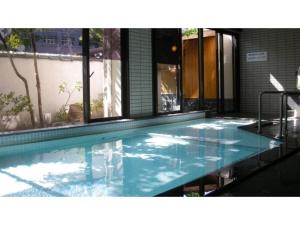 - une piscine d'eau bleue dans un bâtiment dans l'établissement Hotel Tenryukaku - Vacation STAY 16412v, à Fukushima