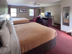 ハーシーにあるRodeway Inn & Suites Hersheyのベッド2台、薄型テレビが備わるホテルルームです。