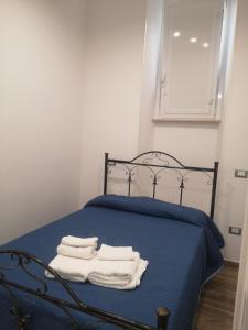 een slaapkamer met een blauw bed en handdoeken bij Terracina Holiday Succursale in Terracina