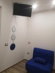 een kamer met een blauwe bank en een tv aan de muur bij Terracina Holiday Succursale in Terracina