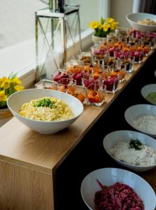 um buffet com tigelas de comida numa mesa em Hotel Eureka em Sopot