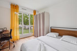 een slaapkamer met een bed, een bureau en een raam bij Duplex apartment downtown with parking in Cergy