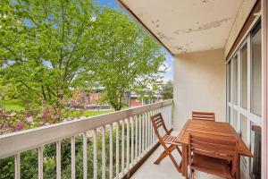 een balkon met een houten tafel en stoelen bij Duplex apartment downtown with parking in Cergy