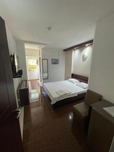 een hotelkamer met een bed en een stoel bij Hotel Millenium2 in Prizren