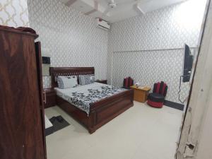 um quarto com uma cama e uma televisão em Hotel Royal Residency em Karachi