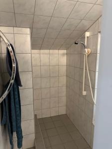 ein Bad mit einer Dusche und blauen Handtüchern in der Unterkunft Gartenhaus - Dietzhäuschen in Suhl