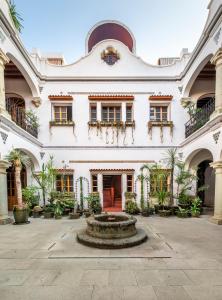 ein großes weißes Gebäude mit einem Brunnen im Innenhof in der Unterkunft Grana B&B in Oaxaca de Juárez