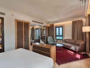 1 dormitorio con cama, escritorio y sofá en The Setai Tel Aviv, a Member of the leading hotels of the world, en Tel Aviv