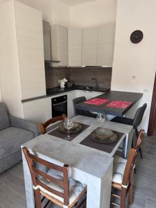 eine Küche mit einem Tisch und Stühlen sowie einem Tisch und einer Küche in der Unterkunft Perseo case vacanze Mameli Apartment in Olbia