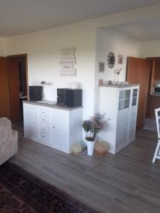 een woonkamer met witte kasten en een keuken bij Ferienwohnungen Sternenhimmel WHG 1 in Medebach