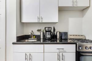 - une cuisine blanche avec évier et cuisinière dans l'établissement Hidden Cozy 2BD apartment In Manhattan, à New York