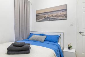 - une chambre dotée d'un lit bleu avec une photo de pont sur le mur dans l'établissement Hidden Cozy 2BD apartment In Manhattan, à New York