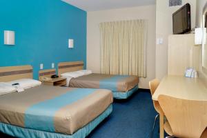 a hotel room with two beds and a table at Motel 6-Peterborough, ON in Peterborough