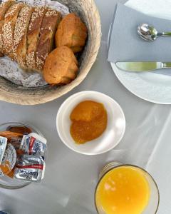 uma mesa com uma cesta de pão e uma tigela de mel em Hotel Miranda em Hydra