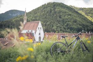 una bicicletta parcheggiata in un campo di fronte a una chiesa di Hotel Kartause a Gaming