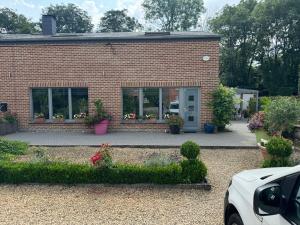 a brick house with flowers in the front of it at Chambre de la Wamme 2 in Marche-en-Famenne