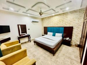 1 dormitorio con cama, sofá y TV en Hotel De Smart Multan, en Multán