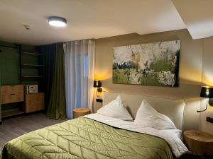 - une chambre avec un lit vert et une peinture murale dans l'établissement Mountains Hotel, à Seefeld in Tirol