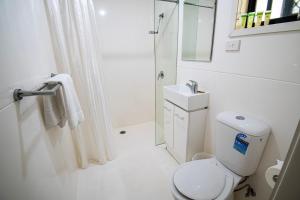 een witte badkamer met een toilet en een wastafel bij Ingenia Holidays Taigum in Brisbane