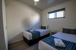 een kleine kamer met 2 bedden en een raam bij Ingenia Holidays Taigum in Brisbane