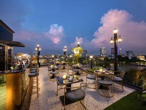 - un restaurant avec des tables et des chaises sur un balcon la nuit dans l'établissement L'Signature Hotel & Spa, à Hanoï