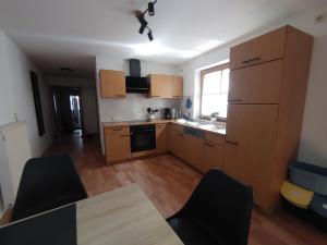 a kitchen with wooden cabinets and a table with chairs at Haus Blumenampel in Schmalkalden