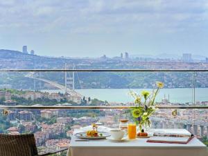 einen Tisch mit Speisen und Stadtblick in der Unterkunft Raffles Istanbul in Istanbul