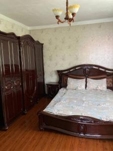 ein Schlafzimmer mit einem Holzbett und einem Kronleuchter in der Unterkunft A room in an Alpine lodge in Almaty