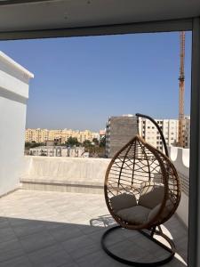 RoofTop Aouina Deluxe sans assesseur في العوينة: كرسي ratan جالس على السطح