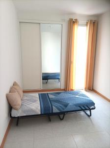 a bedroom with a bed and a large mirror at Casa Do Encanto in Praia