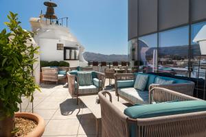 een balkon met banken en stoelen in een gebouw bij Catalonia Ronda in Ronda