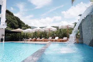 einen Pool mit Stühlen, Sonnenschirmen und einem Brunnen in der Unterkunft Sea View Hotel in Himarë