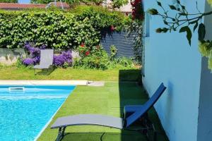 a chair sitting next to a swimming pool at Le Dragon - Appartement centre, Piscine partagée, Wifi, Jardin, Gare à 500m in Niort