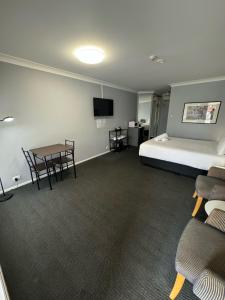 um quarto com uma cama, uma mesa e cadeiras em Old Maitland Inn em Maitland