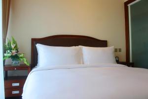 A bed or beds in a room at Kantharyar Serviced Apartment