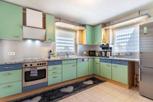 een keuken met blauwe en groene kasten en apparaten bij Ferienwohnung Leon in Kappel-Grafenhausen