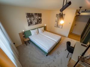 um quarto com uma cama, uma secretária e uma cadeira em Craft Inn - Boutique Hotel em Sibiu