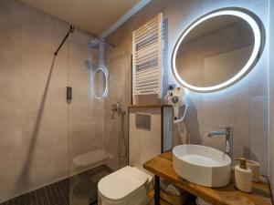 uma casa de banho com um lavatório, um espelho e um WC. em Craft Inn - Boutique Hotel em Sibiu