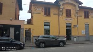 dois carros estacionados em frente a um edifício amarelo em Casa Vanda em Luino