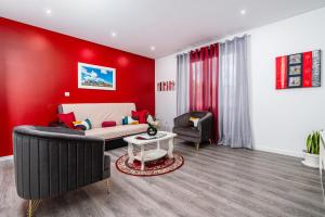 - un salon rouge avec un canapé et une chaise dans l'établissement Roraima House - Private Pool & Garden, à Calheta