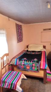 - une chambre avec un lit et une couverture dans l'établissement BLUE SKY Amantani Lodge, à Ocosuyo