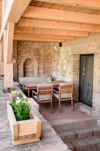 patio con mesa, sillas y pared de ladrillo en Villa Daniela, en Úvaly