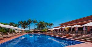 a swimming pool with lounge chairs and umbrellas at Hotel Villa Rossa in São Roque