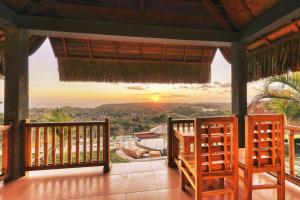 uma varanda com vista para o pôr-do-sol em Sebuluh Sunset Hill em Nusa Penida