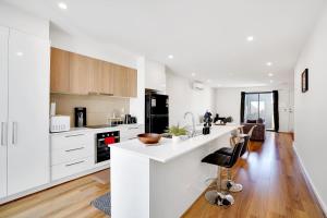 a kitchen with white cabinets and a white counter top at Cozy Townhouse in Werribee centre in Werribee