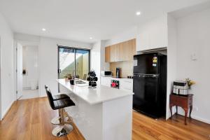 a kitchen with a black refrigerator and a white counter top at Cozy Townhouse in Werribee centre in Werribee